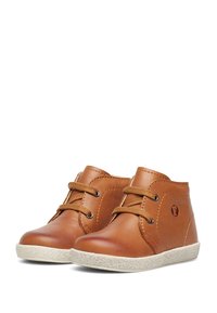 Botas de cuero marrón hasta el tobillo con punteras redondeadas, cordones color canela y suelas de goma texturizada para mayor tracción. Presenta un detalle del logo en el lateral.