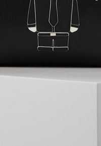 Black background featuring a white outline of a suit with a tie, illustrating a business attire design. The shape is rectangular and sleek.
