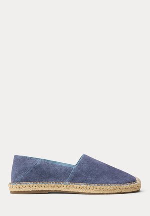 Blue canvas espadrille with woven jute sole and flat rubber bottom, slip-on style viewed from the side on a white background.