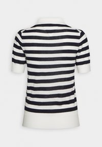 Chemise en maille à manches courtes avec des rayures horizontales noires et blanches et un col blanc, vue de dos sur un fond uni.