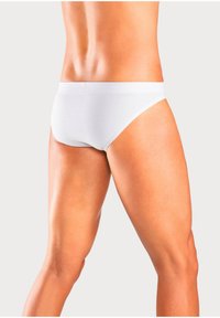 Weiße Baumwollunterhosen mit glattem Textil und elastischem Bund, seitlich an einem Model mit durchtrainierten Beinen abgebildet.