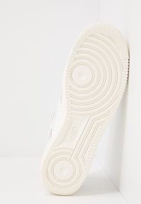 Vit sportig sneakersula med rund- och spiralmönster, texturerad gummi för grepp, med en slät sidoprofil och minimal branding.