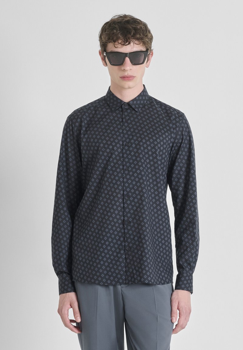Camicia a maniche lunghe con bottoni in tessuto blu scuro caratterizzata da un motivo a diamante. Texture opaca con colletto e polsini classici.