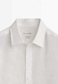 Witte linnen blouse met lange mouwen, puntige kraag en zichtbare knopen, gemarkeerd als maat L, gemaakt van 100% linnen, geverfd en gewassen.