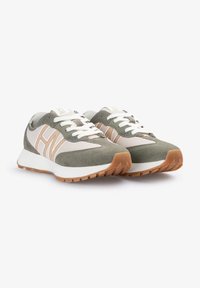 Zapatillas con una parte superior de gamuza en gris verdoso, acentos de malla beige y cordones blancos. Presenta una suela de goma texturizada en tono marrón con una entresuela blanca.
