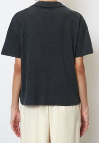Dunkelgraues Poloshirt mit kurzen Ärmeln aus einem strukturierten Stoff, mit einer lockeren Passform und einem klassischen Kragen. Rückansicht dargestellt.