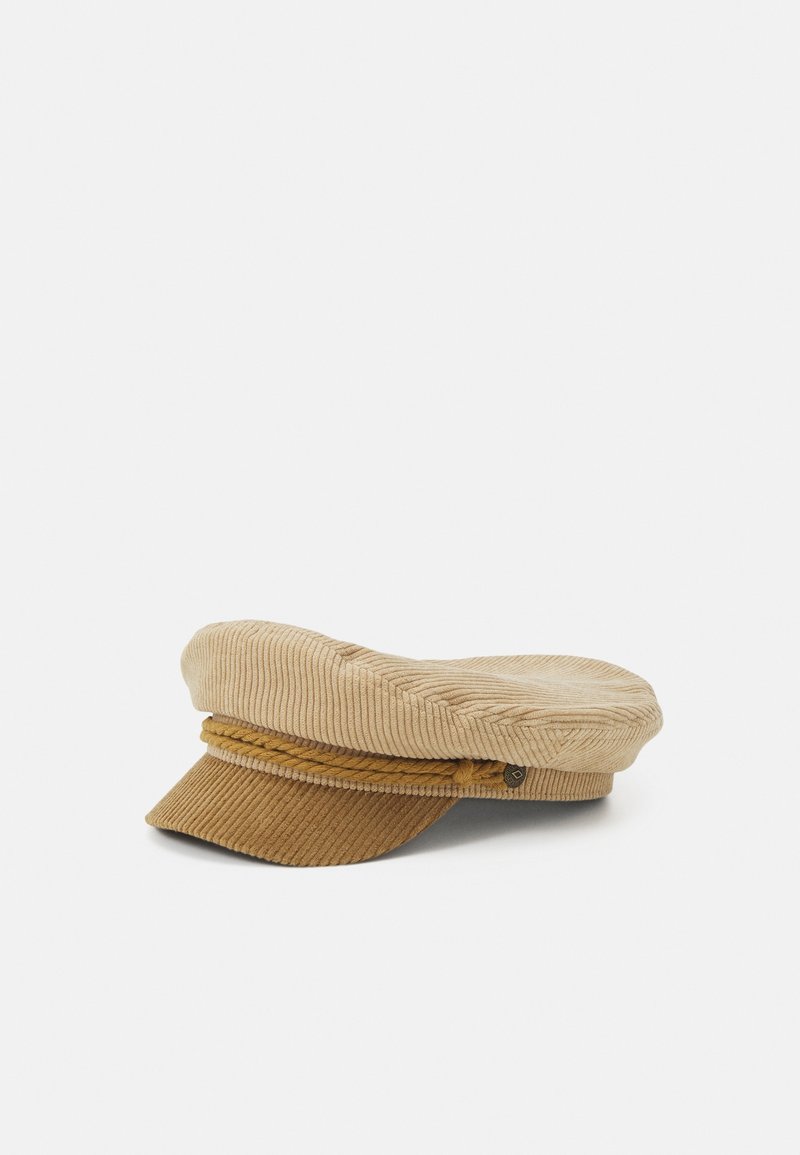 Casquette gavroche en velours côtelé beige avec un détail en corde tressée au-dessus de la petite visière avant, posée sur une surface blanche.