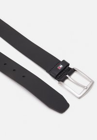 Zwarte leren riem met een zilveren vierkante gesp, voorzien van een merkaccent van leer nabij de gesp en meerdere verstelgaten langs de band.