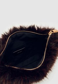 Fauxfurpung med en mörkbrun utsida, guldzipper och en svart fodrad insida som har en extra ficka för organisation.