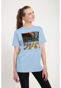 Světle modré bavlněné tričko s grafikou čtyř barevných medvědů přecházejících ulici s duhou v pozadí. Krátké rukávy.