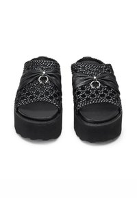 Sandali platform neri con tomaia intrecciata, decorati con accenti di tessuto annodato e un dettaglio a forma di anello metallico. Suola in gomma texturizzata per una migliore aderenza.