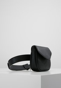 Borsa a tracolla in pelle nera con chiusura a patta e spallaccio spesso, caratterizzata da una texture liscia e un design minimal. Compatta e versatile.