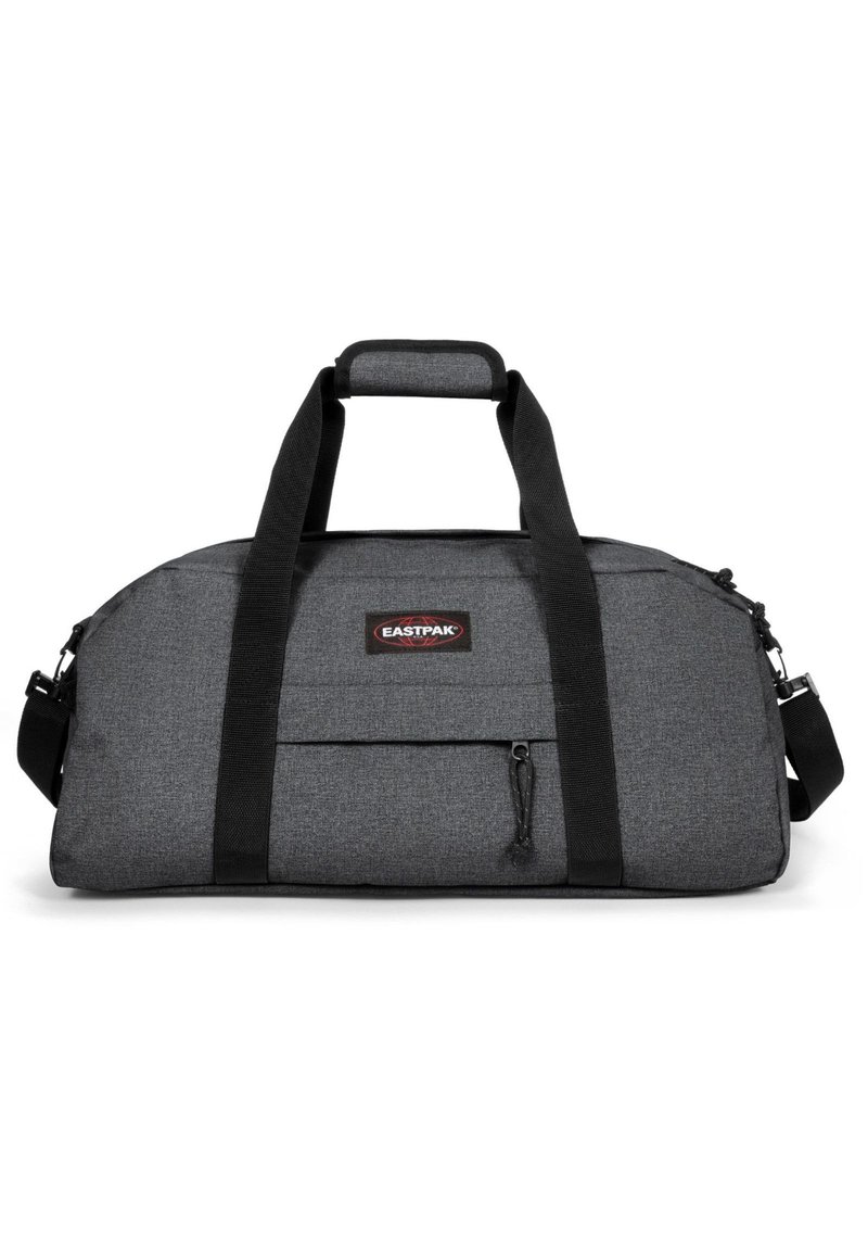 Šedá sportovní taška s černými popruhy, vyrobená z texturované látky. Obsahuje přední zipovou kapsu a nastavitelný ramenní popruh. Zobrazeno logo Eastpak.