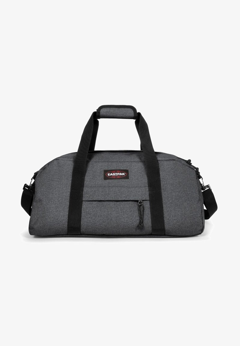 Šedá sportovní taška s černými popruhy, vyrobená z texturované látky. Obsahuje přední zipovou kapsu a nastavitelný ramenní popruh. Zobrazeno logo Eastpak.