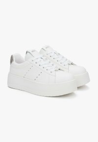 Witte platform sneakers van glad leer, met geperforeerde accenten, platte veters en een gestructureerde hakafwerking.