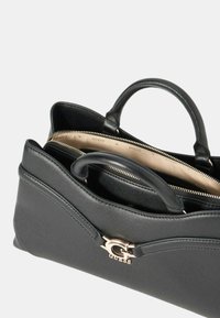 Borsa in pelle nera con due manici corti, accentata da un logo dorato e chiusura a cerniera; l'interno presenta un rivestimento di colore chiaro.