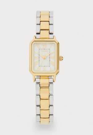 Gold and silver metal wristwatch with a rectangular face, Roman numerals, and a textured white dial. Features a two-tone linked bracelet.