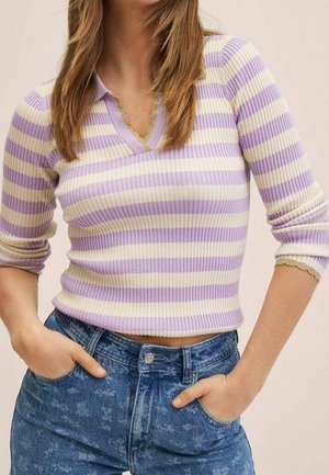 Femme portant un haut à manches longues côtelé rayé violet et crème avec un col et un jean bleu taille haute, mains dans les poches.