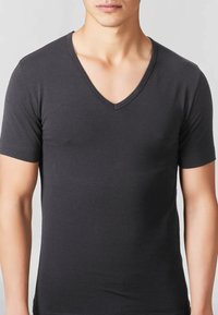 T-shirt nera a maniche corte con scollo a V realizzata in soffice tessuto, caratterizzata da un design attillato e una texture liscia. Senza motivi o dettagli particolari.