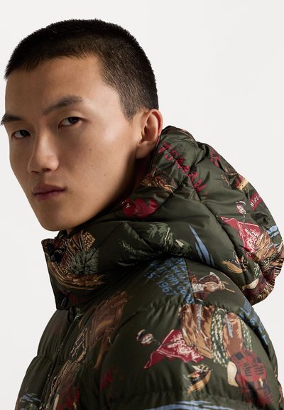 Puffer jacket in dark green fabric with a glossy texture, featuring a multicolored print of nature and outdoor-themed illustrations.