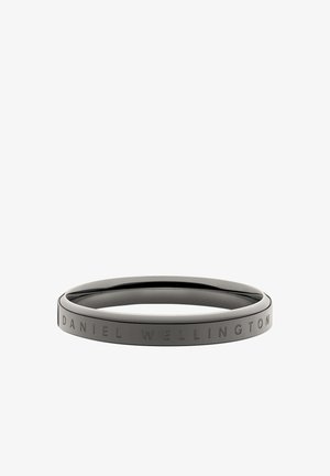 Juodas nerūdijančio plieno bangelis su lygiu, suapvalintu pavidalu; vienoje pusėje yra išgraviruotas tekstas "DANIEL WELLINGTON".