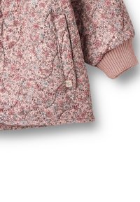 Pikowana kurtka w kwiaty w kolorze różowym, z prążkowanymi mankietami, boczną kieszenią oraz wzorzystą tkaniną zdobioną małymi kwiatami w odcieniach różu i szarości.