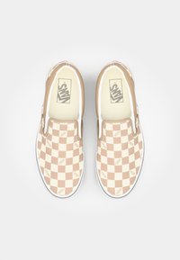 Bež-bijele karirane slip-on tenisice s Vans logom, elastičnim bočnim akcentima i bijelim gumenim đonom. Glatka tekstura i ležeran dizajn.
