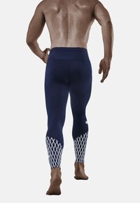 Marineblauwe sportleggings met een gestructureerd ruitpatroon op de onderbenen, voorzien van een achterzak en een gladde, nauwsluitende pasvorm.