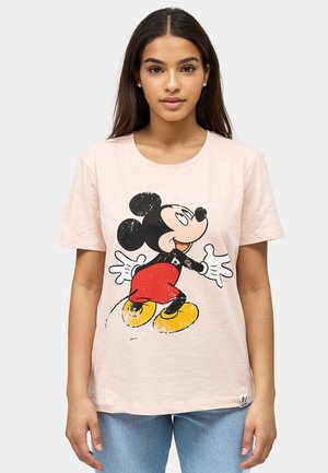 Camiseta de algodón rosa claro con un estampado desgastado de un personaje de caricatura en negro, rojo y amarillo. Mangas cortas, escote redondo.