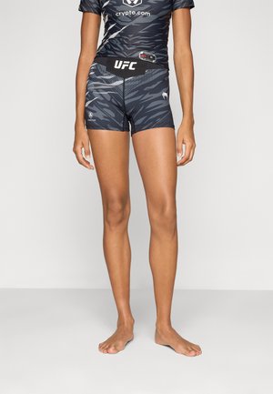 UFC-merket atletisk bekledning som inkluderer en tettsittende, kortermet topp og matchende shorts, begge i mørkeblå med et teksturert tigerstripe-mønster.