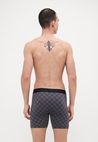 Boxeri pentru bărbați, de culoare gri, cu un model geometric subtil în nuanță de negru. Material moale cu un brâu elastic negru. Croială și stil tradițional.