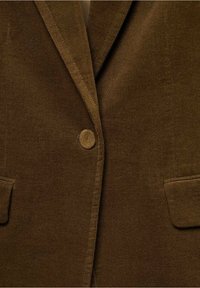 Brązowa marynarka sztruksowa z wyciętym klapą, pojedynczym zapięciem na guzik oraz dwoma przednimi kieszeniami o miękkiej fakturze.