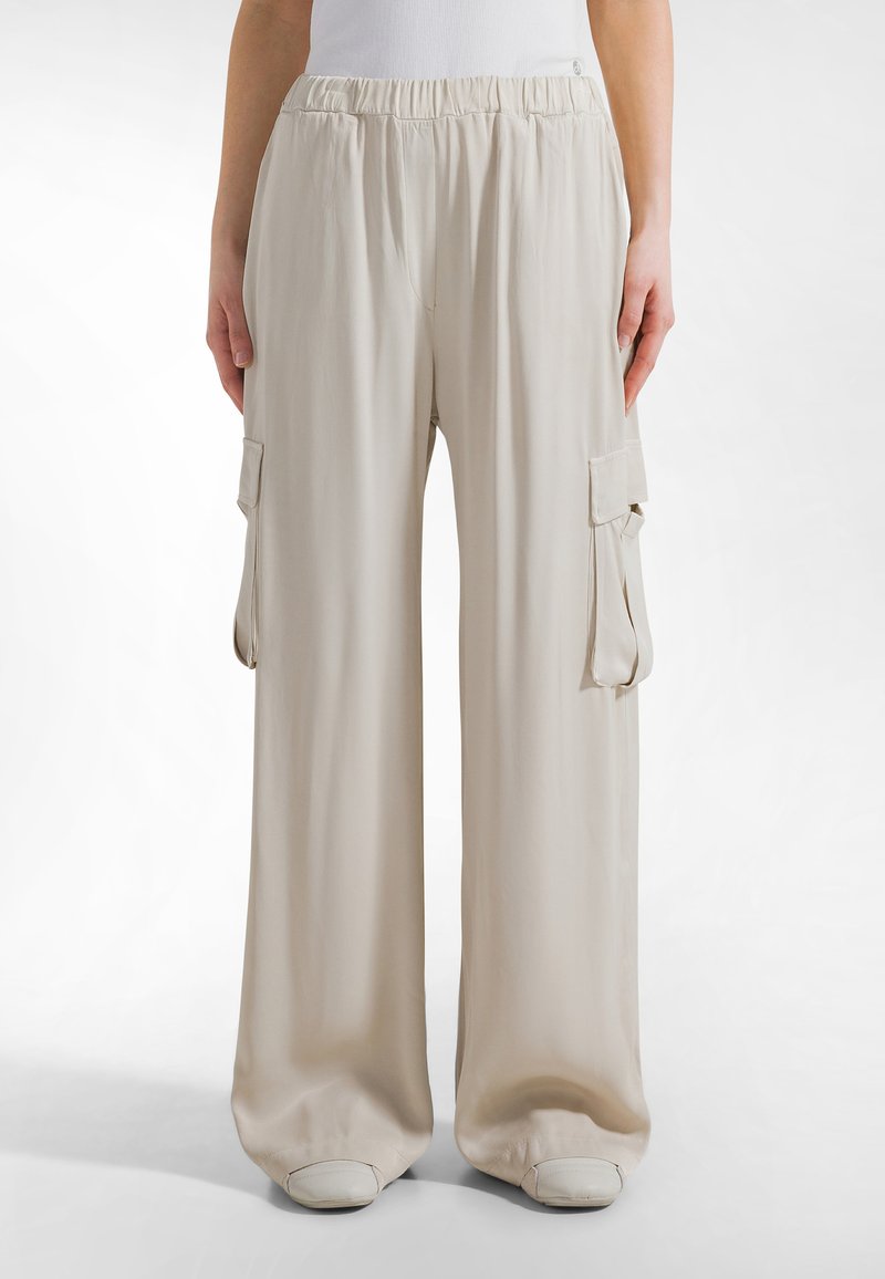Lichtbeige wijde cargo broeken met een elastische tailleband, voorzien van twee zijzakken en een gladde, zachte stoftextuur.