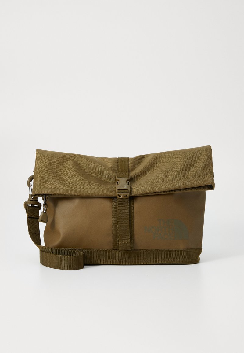 Borsa verde a roll-top realizzata in tessuto resistente. Presenta una fibbia frontale, una tracolla regolabile e un logo stampato, con una texture liscia.