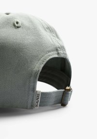 Grå bomulds baseball cap med en struktureret krone, buet skygge og justerbar rem med en metal spænde samt et vævet mærke på siden.