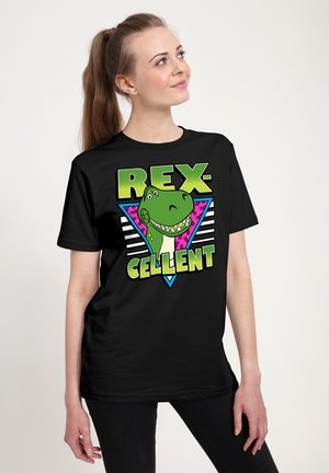 Czarna koszulka z zielonym graficznie przedstawionym dinozaurem w stylu kreskówkowym oraz napisem "REX-CELLENT" w jaskrawym zielonym i różowym kolorze, na tle w stylu geometrycznym.