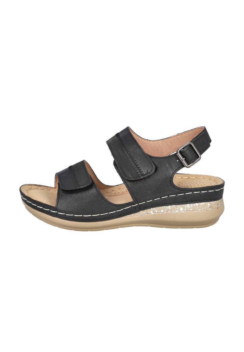 Sandalia negra con dos correas ajustables de Velcro, plantilla acolchada y suela de cuña beige con un acento brillante.