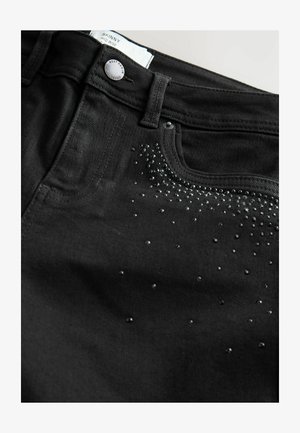 Sorte skinny jeans med mellemhøj talje, der har en glat overflade og dekorationer af små blanke nitter langs frontlommen.