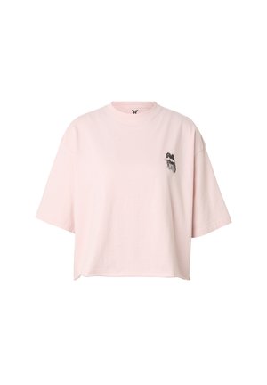 Lichtroze oversized T-shirt met korte mouwen en een kleine zwart-witte vlinderafbeelding op de linkerborst.