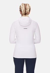 White long-sleeve hoodie with a textured, striped design. Features a hood and the brand name "MAMMUT" printed in black on the back.