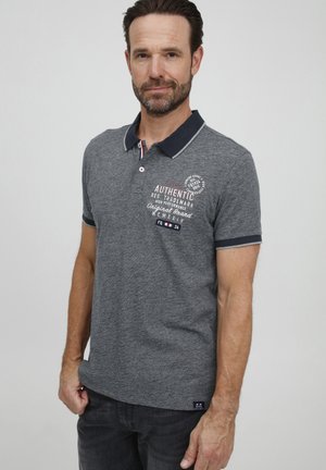 Grey polo shirt with a contrasting navy collar. Features graphic print on the chest and short sleeves. Slim fit with side vents.