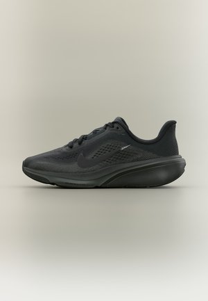 Chaussure de running noire Nike avec une tige en tissu texturé, une semelle amortie et un logo Swoosh sur le côté, vue du côté extérieur sur un fond uni.