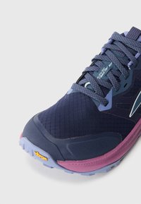 Herre løpesko i mørk marineblå og lilla. Har strukturert mesh-overdel, solid såle med Vibram-merke og reflekterende detaljer.