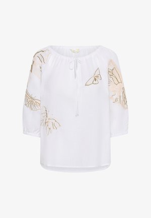 Blouse blanche à manches 3/4, col froncé avec lien, et broderie beige de papillon sur les manches et la poitrine.