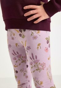 Lilla blomster leggings med en blød tekstur prydes af forskellige plante mønstre i gul, pink og grøn. Kombineret med en bordeaux farvet top.