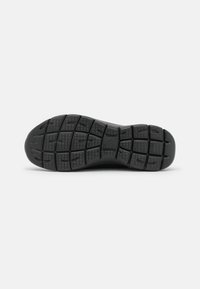 Svart sneaker sula med texturerad gummi för grepp, med ett mönstrat träddesign och spår för flexibilitet.