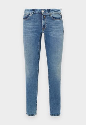 Jeans skinny en denim azul claro con una textura suave. Presenta cinco bolsillos, pasadores para cinturón y un cierre clásico de botón y cremallera.