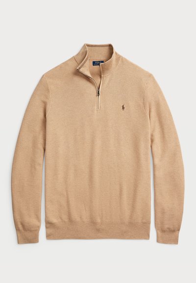 Beige zip-neck genser laget av teksturert strikket stoff med ribbestrikkede mansjetter og nederkant; har et lite logo på brystet.