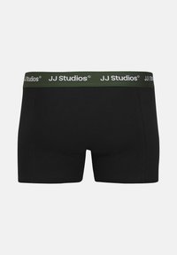 Boxer in cotone neri con una fascia verde che presenta il marchio "JJ Studios" in bianco. Texture liscia, design aderente e lunghezza corta della gamba.