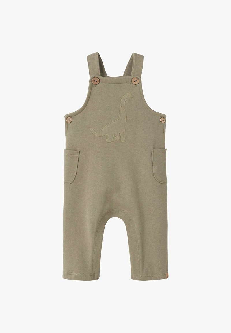 Zöld pamut kantárosnadrág dínó hímzéssel, fából készült gombokkal és két oldalsó zsebbel. Rövidnadrág stílusú lábak és sima textúra jellemzi.